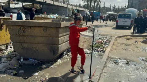 Getty Images Girl filling up a bucket from a tap in Gaza