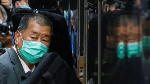 Jimmy Lai, wearing a face mask, arriving in court in 2023 