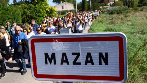 Reuters People march through Mazan