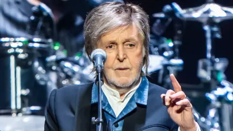 Close up of Sir Paul McCartney performing  at The O2 Arena with his fist in the air