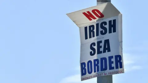 Reuters A poster reading "No Irish Sea border" displayed in the port of Larne, Northern Ireland, in June 2022