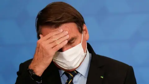 Reuters Brazil's President Jair Bolsonaro gestures during a ceremony to announce measures by Caixa Economica bank in support of philanthropic hospitals, in Brasilia, Brazil March 25, 2021.