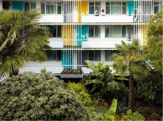 the burrard hotel with 4 people on the third level balcony