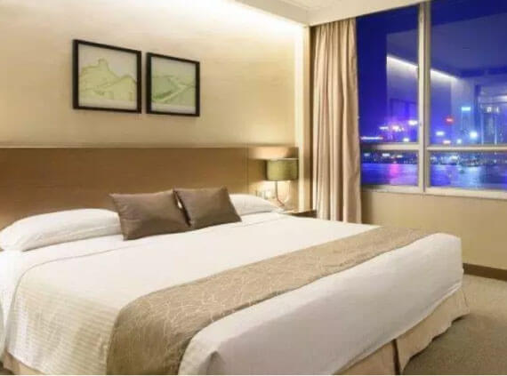 a king bed with white and brown sheets inside a salisbury hotel room