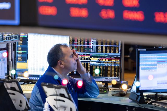 A trader at his computer terminal as news of the Federal Reserve rate cut decision are show on TV at the New York Stock Exchange in New York New York USA 18 December 2024 사진연합뉴스