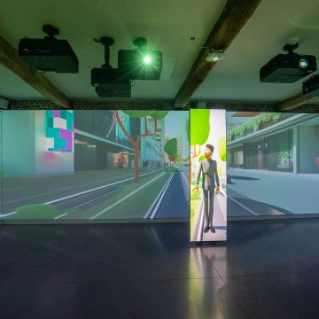 Three children playing soccer in an X-Wall immersive room with educational projection content.