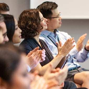 A group of people clapping in an exciting briefing.