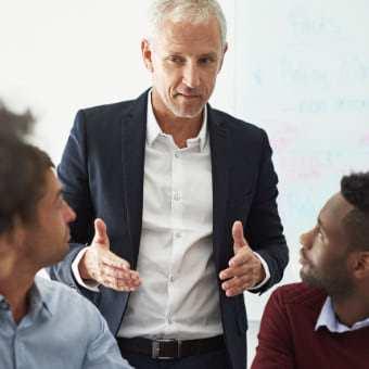 A leader standing up guiding employees.