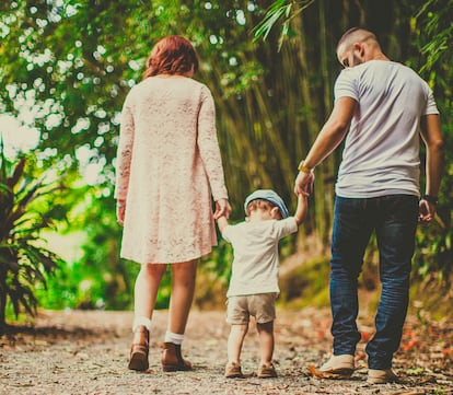 Unos padres caminan con sus padres por un bosque.