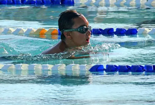 Boy swimming laps in a pool.