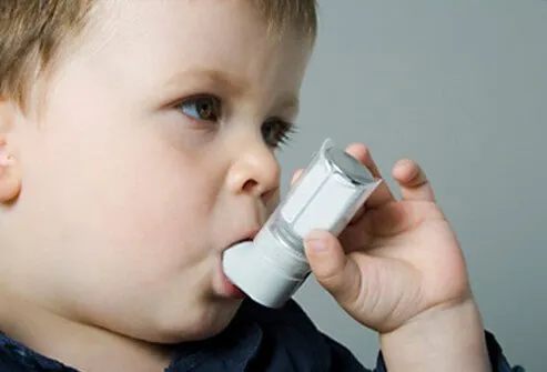 Boy using and asthma inhaler.