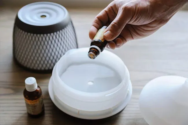 Put a few drops of a scented oil into a diffuser or a spray bottle filled with water.