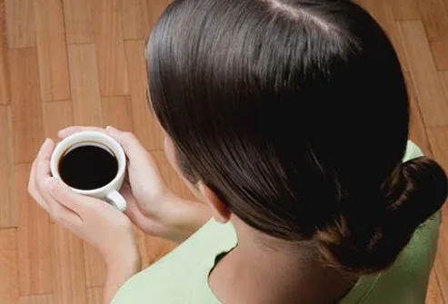 A woman holding a cup of coffee.