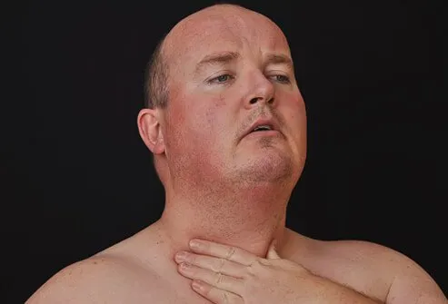 A man checks his neck and throat.