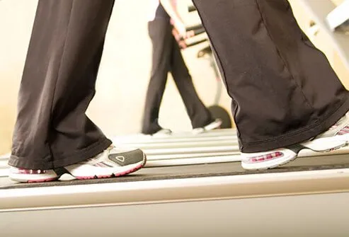 A woman warms up on a treadmill.