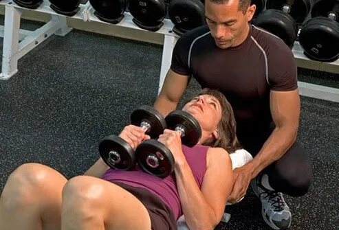 A woman works out with a trainer.