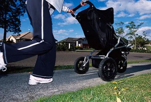 A mother jogs with her child in a stroller.