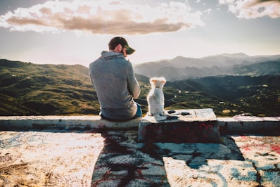 man sitting beside dog