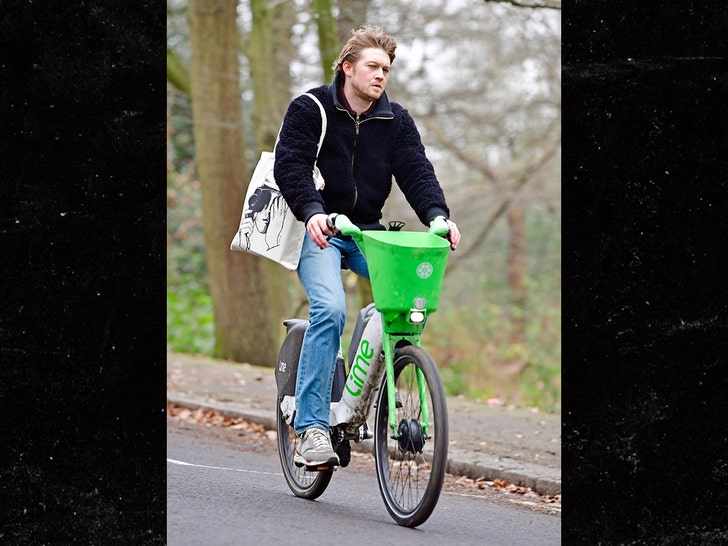 Joe Alwyn looks a little disheveled as he enjoys a Lime Bike ride on Boxing Day in London