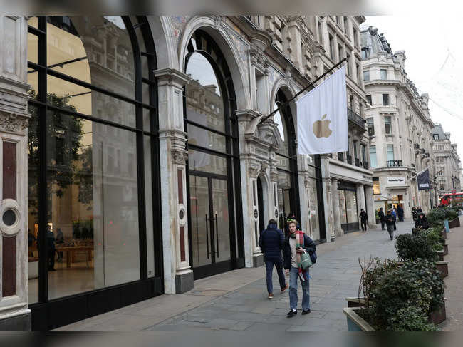 People walk past an Apple store in London