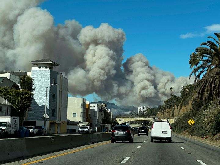 Heavy smoke from a brush fire in the Pacific Palisades rises over the Pacific Coast Highway in Santa Monica, Calif., on Tuesday, Jan. 7, 2025. (AP Photo/Eugene Garcia)