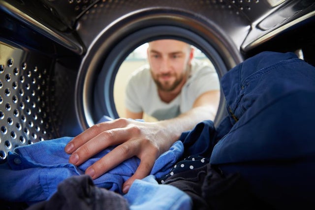 Person reaching into washing machine