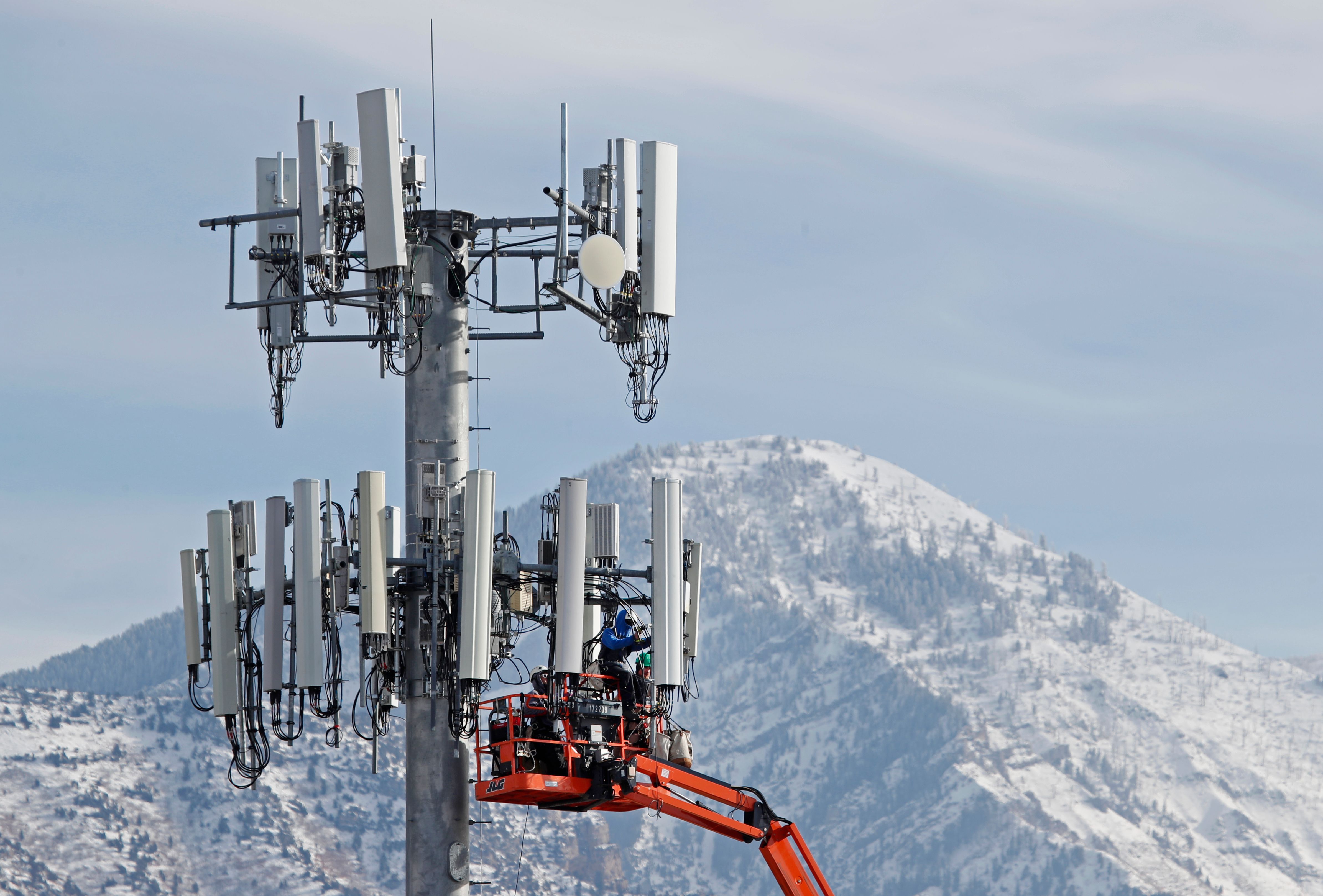 A contract crew for Verizon, works on a cell tower to update it to handle the new 5G network in Orem, Utah