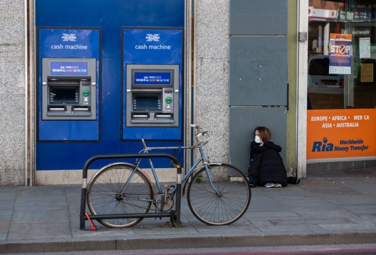 A homeless woman wearing a face mask