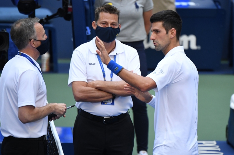 Sep 6, 2020; Flushing Meadows, New York, USA; Novak Djokovic of Serbia discusses with a tournament official after being defaulted for striking a lines person with a ball against Pablo Carreno Busta of Spain (not pictured) on day seven of the 2020 U.S. Open tennis tournament at USTA Billie Jean King National Tennis Center. Mandatory Credit: Danielle Parhizkaran-USA TODAY Sports