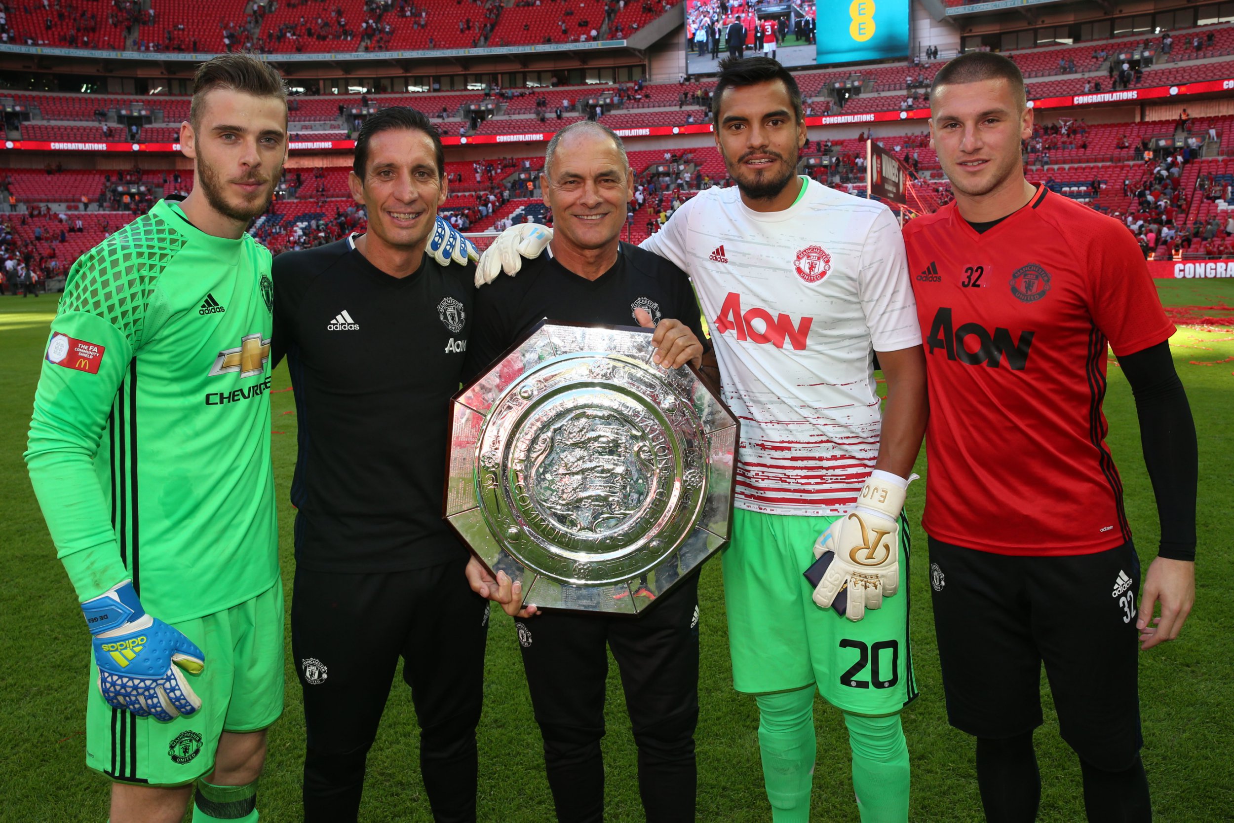 LONDON, ENGLAND - AUGUST 07: David de Gea, Sergio Romero and Sam Johnstone of Manchester United pose with Coach Emilio Alvarez and Coach Silvino Louro with the Community Shield trophy after the FA Community Shield match between Leicester City and Manchester United at Wembley Stadium on August 7, 2016 in London, England. (Photo by John Peters/Manchester United via Getty Images)