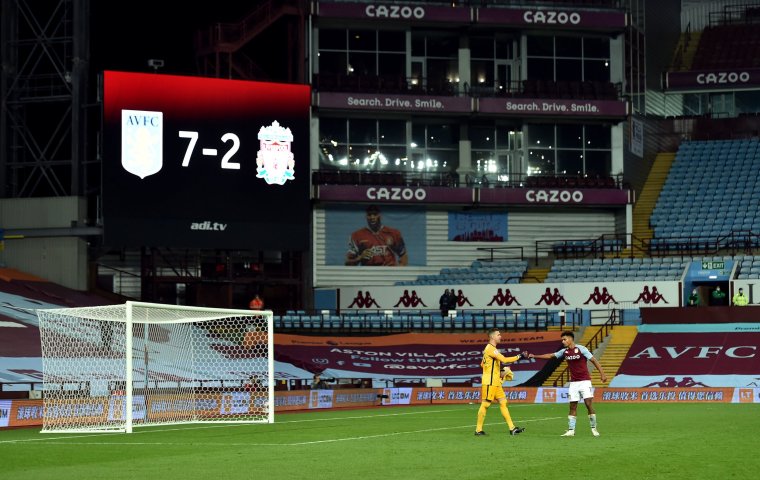 Liverpool goalkeeper Adrian and Aston Villa's Ollie Watkins fist bump after the match in front of the big screen displaying the 7-2 scoreline during the Premier League match at Villa Park, Birmingham. PA Photo. Picture date: Sunday October 4, 2020. See PA story SOCCER Villa. Photo credit should read: Peter Powell/NMC Pool/PA Wire. RESTRICTIONS: EDITORIAL USE ONLY No use with unauthorised audio, video, data, fixture lists, club/league logos or "live" services. Online in-match use limited to 120 images, no video emulation. No use in betting, games or single club/league/player publications.