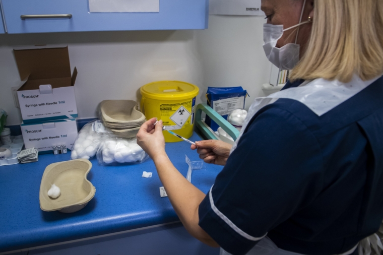 OLDHAM, ENGLAND - JANUARY 11: A nurse draws up a dose of the Pfizer COVID-19 vaccine into a syringe at a vaccination centre at the Royal Health & Wellbeing Centre on January 11, 2021 in Oldham, England. The location is one of several mass vaccination centres in England to open to the public this week. The UK aims to vaccinate 15 million people by mid-February. (Photo by Anthony Devlin/Getty Images)