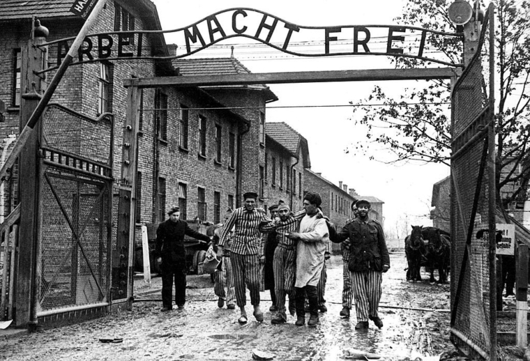 404304 05: Concentration camp victims are led through the Auschwitz-Birkenau camp gate in 1945 in this photo found recently in Moscow. Auschwitz, which is known for one of the biggest Nazi concentration camps during World War II, is a site of many current controversies concerning construction of trade and entertainment centers near and on the former concentration camp grounds. A few years ago protests stopped the construction of a disco. Today an official opening took place for a car park and tourist service center in Oswiecim/Auschwitz, built by the building company, Maja. Maja already wanted to build a supermarket in the area, but was also stopped by protests. Out of several buildings, one, which hosts a fast food restaurant, is placed in the "protected zone" and had to receive approval from the local authorities. (Photo by Wojtek Laski/Getty Images)