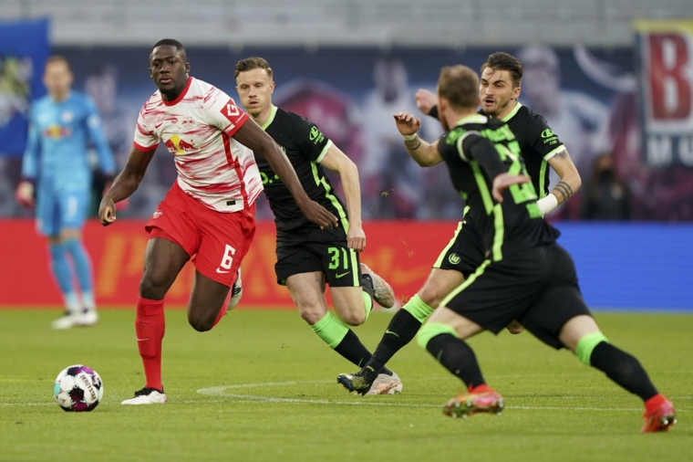 Leipzig's Ibrahima Konate, left, and Wolfsburg's Yannick Gerhardt challenge for the ball during the Bundesliga soccer match between RB Leipzig and VfL Wolfsburg in Leipzig, Germany, Sunday, May 16, 2021. (AP Photo/Michael Sohn, pool)