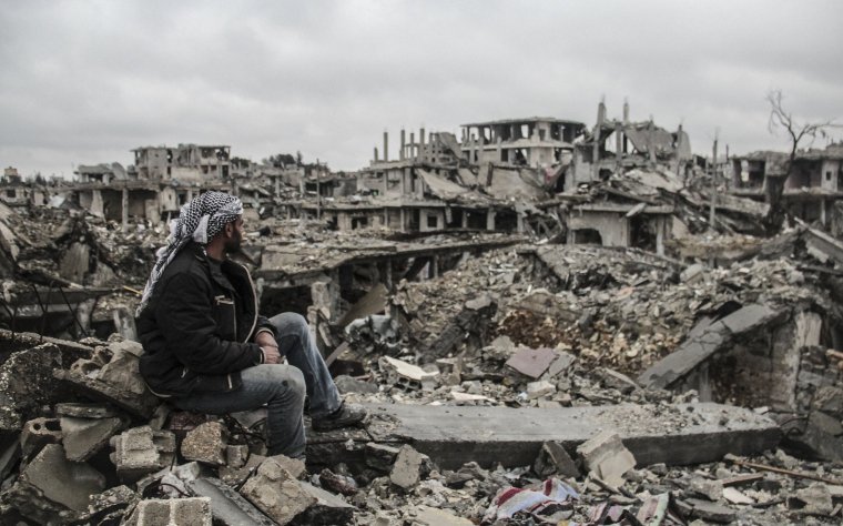 A man looks at the rubble of buildings destroyed in the clashes between DAESH militants and Kurdish armed armed groups in the center of the Syrian town of Kobani (Ayn al-Arab), Aleppo on March 12, 2015 after it has been freed from DAESH militants. (Photo by Halil Fidan/Anadolu Agency/Getty Images)