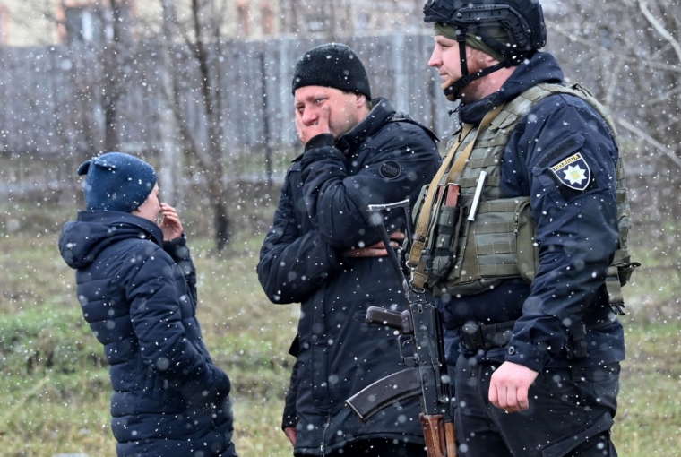 People react as they gather close to a mass grave in the town of Bucha, just northwest of the Ukrainian capital Kyiv on Sunday (Photo: Sergei Supinsky/AFP via Getty Images)