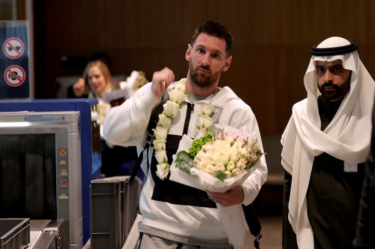 Paris Saint-Germain's Lionel Messi and members of the PSG team arrive at an airport in the Saudi capital Riyadh, on 19 January 2023, ahead of a friendly football match as part of the Riyadh Season Cup, against a select side made up of players from Cristiano Ronaldo's new club Al Nassr and their Saudi rivals Al Hilal. - Besides Messi, PSG stars expected to play include France striker Kylian Mbappe and Achraf Hakimi, who last year in Qatar helped make Morocco the first Arab and African team to reach the World Cup semi-finals. The Saudi select team includes Salem Al-Dawsari, who scored the winning goal in the Green Falcons' shock defeat of Argentina in the World Cup's group stage. (Photo by Fayez Nureldine / AFP) (Photo by FAYEZ NURELDINE/AFP via Getty Images)