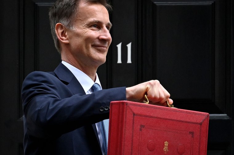 Britain's Chancellor of the Exchequer Jeremy Hunt poses with the red Budget Box as he leaves 11 Downing Street in central London on March 15, 2023, to present the government's annual budget to Parliament. (Photo by JUSTIN TALLIS / AFP) (Photo by JUSTIN TALLIS/AFP via Getty Images)