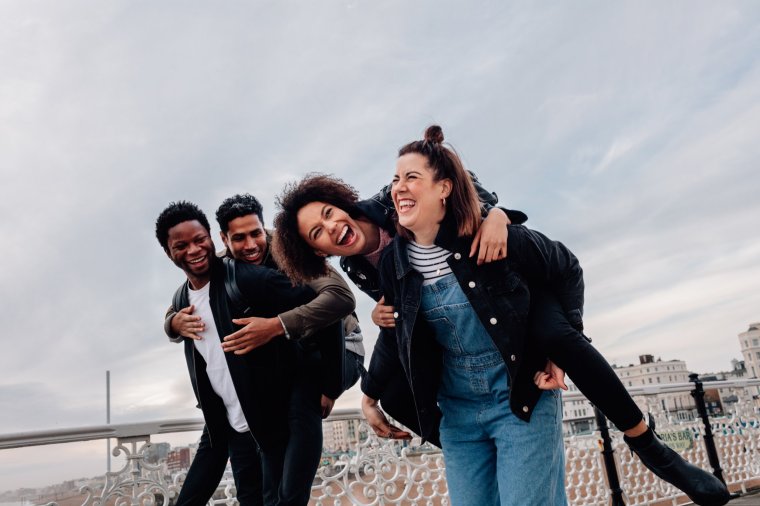 Mixed race couples on a day out at seaside having fun.