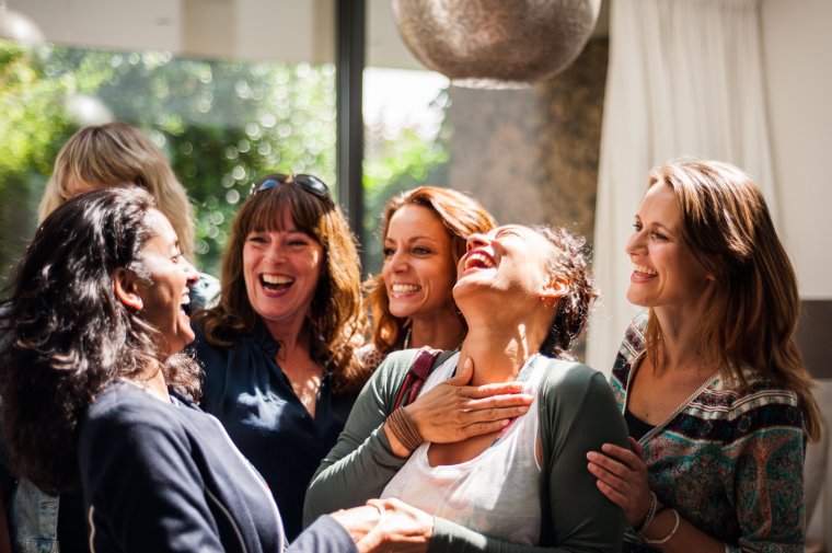 Group of women seeing one another at reunion. Lots of happiness and fun.