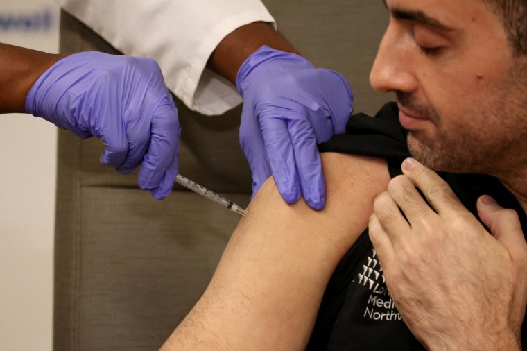 FILE PHOTO: Adam Berman, MD Associate Chair emergency medicine Long Island Jewish Medical Center, who was one of the first Americans to receive the initial COVID vaccine, is inoculated with the updated coronavirus disease (COVID-19) vaccine by Dr. Michelle Chester from Northwell Health at Long Island Jewish Medical Center in New Hyde Park, New York, U.S., September 13, 2023. REUTERS/Brendan McDermid/File Photo