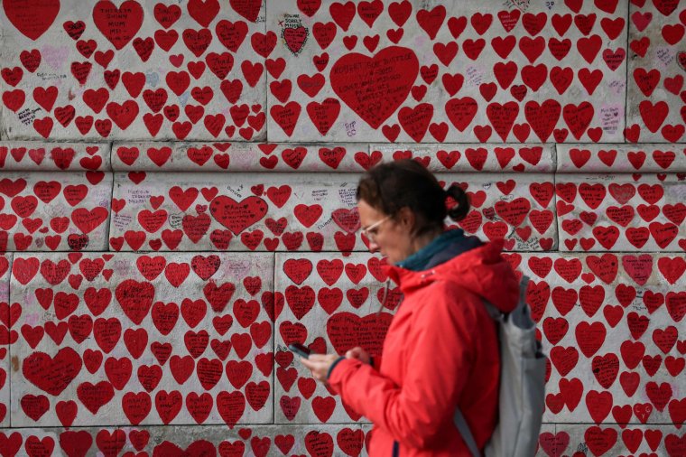 A pedestrian walks past the National Covid Memorial Wall, dedicated to those who lost their lives to Covid-19, on the embankment on the south side of the River Thames in London on October 31, 2023. An enquiry probing the UK government's handling of the coronavirus pandemic chaired by retired senior judge Heather Hallett, focuses in the second phase on political governance and decision-making. (Photo: Daniel Leal/AFP via Getty)