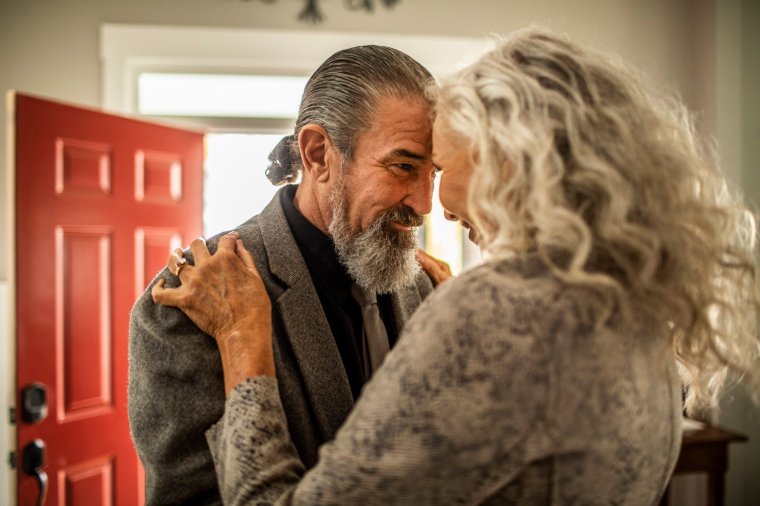 Senior couple embracing in entryway of home