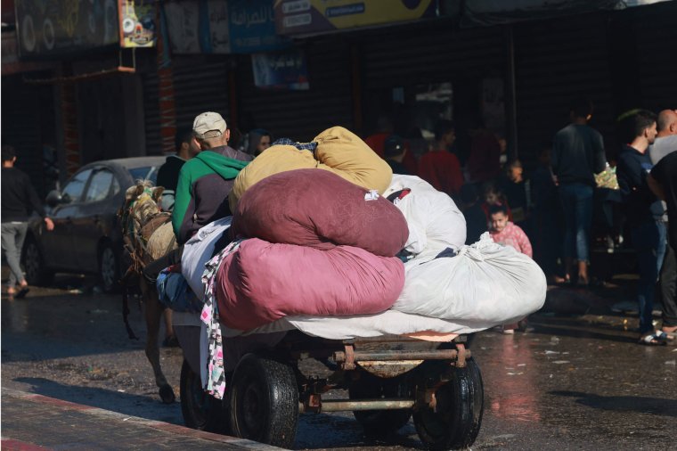 A Palestinian man drives a donkey cart laden with bags of clothes in Bureij in the central of Gaza Strip, on November 14, 2023, amid the ongoing battles between Israel and the Palestinian group Hamas. (Photo by MOHAMMED ABED / AFP) (Photo by MOHAMMED ABED/AFP via Getty Images)