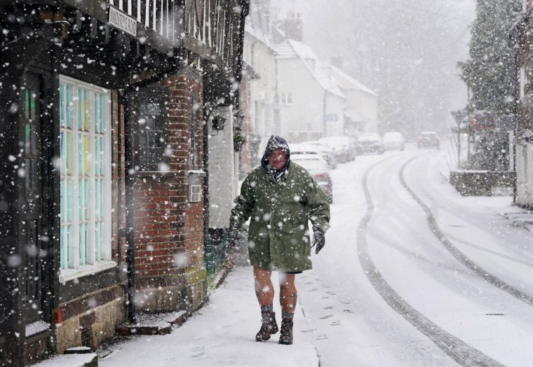 People walking through a snow flurry in Lenham, Kent. Sleet and snow showers have been forecast for parts of the country on Monday as some regions are still trying to grapple with flooding following intense rainfall. Picture date: Monday January 8, 2024. PA Photo. See PA story WEATHER Cold. Photo credit should read: Gareth Fuller/PA Wire