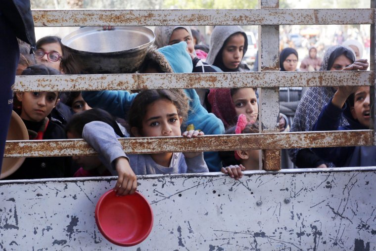 DEIR AL BALAH, GAZA - JANUARY 28: Palestinians including children, struggling with starvation, are seen waiting in front of the food aid stand to receive food distributed by charity organisations, amid ongoing Israeli attacks in Deir Al Balah, Gaza on January 28, 2024. (Photo by Ashraf Amra/Anadolu via Getty Images)