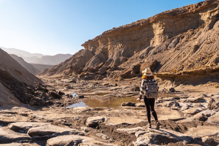 A young woman on a trek in the Travertino waterfall and Rambla de Otero in the Tabernas desert one spring afternoon, Almer??a province, Andalusia