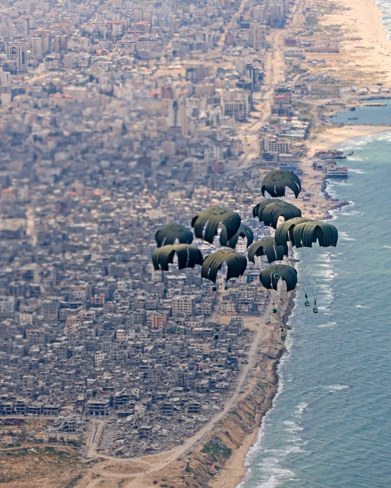 UNSPECIFIED, GAZA - MARCH 25: In this handout photo provided by the MOD (Ministry of Defence) humanitarian aid including water, rice, cooking oil, flour, tinned goods and baby formula is airdropped over Gaza from a RAF A400M aircraft on March 25, 2024 over Gaza. The Royal Air Force airdropped over 10 tonnes of food supplies into Gaza for the first time today as part of international efforts to provide life-saving assistance to civilians. The RAF A400M flew from Amman, Jordan to airdrop this aid along the northern coastline of Gaza, as part of the Jordanian-led international aid mission. UK personnel worked closely with the Royal Jordanian Air Force to plan and conduct this mission. (Photo by AS1 Leah Jones/MOD via Getty Images)