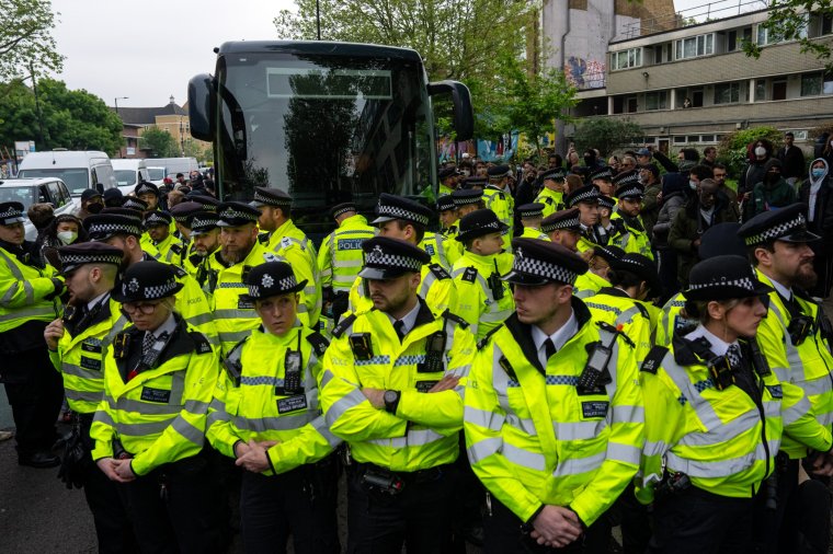 LONDON, ENGLAND - MAY 2: Police officers surround a bus that was to be used to carry migrants from a hotel on May 2, 2024 in Peckham, London, England. Protest groups including the Antiraids Network have vowed to stop migrant removals by the Home Office from hotels and premises across the UK. The Government passed the controversial Rwanda Bill last week and has set about detaining migrants ahead of deportation to Rwanda. (Photo by Carl Court/Getty Images)