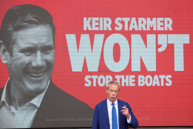 Britain's Reform UK Party Leader Nigel Farage delivers a speech in front of a campaign advert featuring an image of British opposition Labour Party leader Keir Starmer, during a campaign event, in Blackpool, Britain, June 20, 2024. REUTERS/Phil Noble